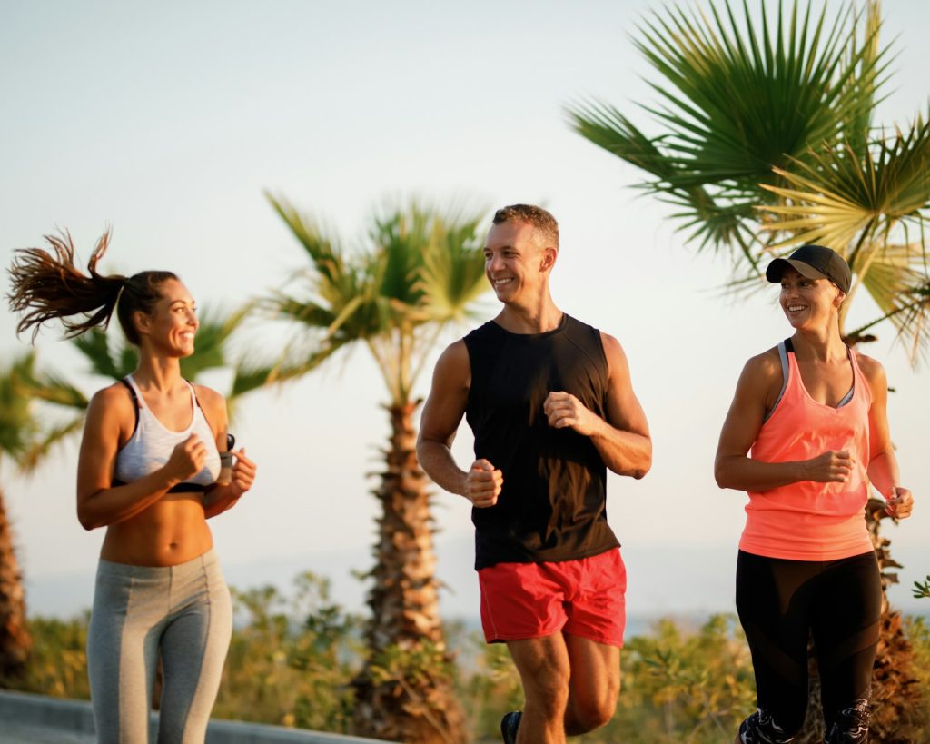 Grup mic de sportivi fericiți care fac jogging împreună în natură.